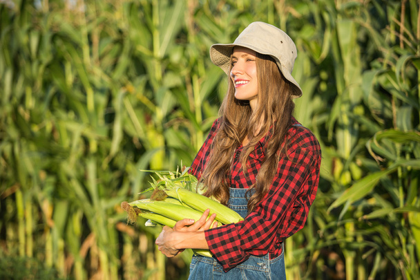 Organic female farmer holding sweetcorn - Photo, Image