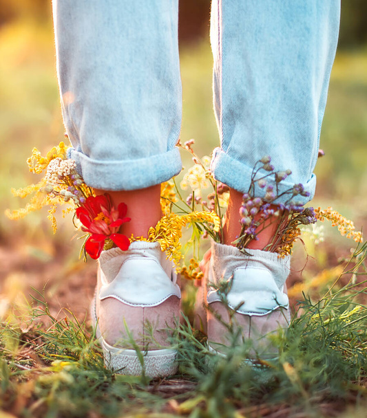 Schöne Wildblumen in Schuhen auf einem Sommerfeld. Sommerlicher Hintergrund - Foto, Bild