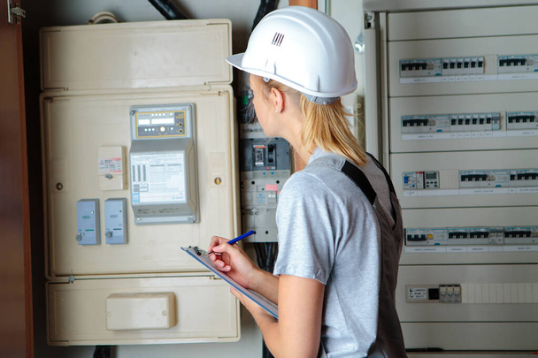 electrician woman solving problem on electrical board - Foto, immagini