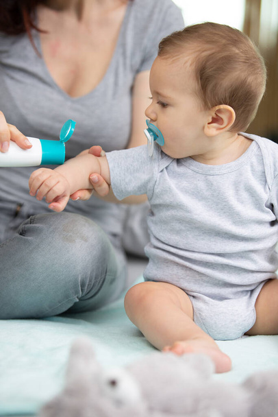 mother applying cream to babys arm - Zdjęcie, obraz