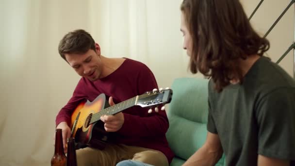 Kaksi ystävää soittaa kitaraa ja laulaa lauluja. - Materiaali, video