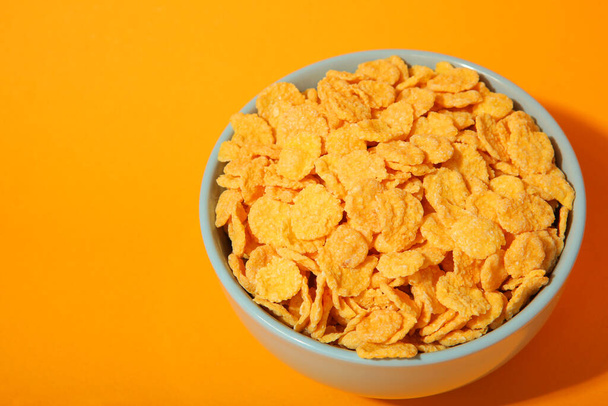 Delicious cornflakes in a plate against colored background.  - Photo, Image