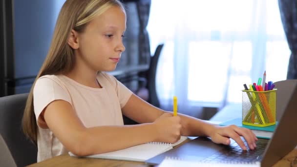 Liseli kız internetten modern bir dizüstü bilgisayar kullanıyor. Ev ödevi - Video, Çekim