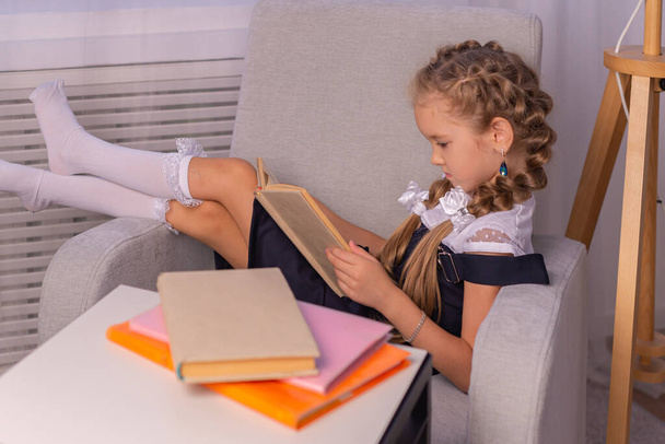 scolaretta leggere un libro a casa. concetto di scolarizzazione a casa - Foto, immagini