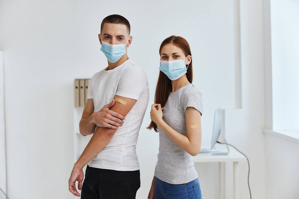 hombre y mujer con máscaras médicas en el pasaporte de la vacuna del hospital inmunidad sanitaria - Foto, imagen