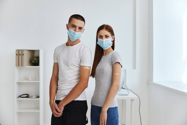 νεαρό ζευγάρι που φοράει ιατρικές μάσκες Διαβατήριο εμβολίου προστασία νοσοκομειακής ασυλίας - Φωτογραφία, εικόνα