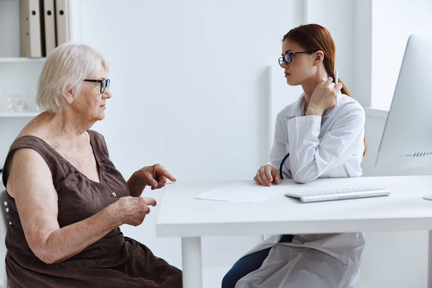 donna anziana con occhiali che parla con l'infermiera diagnostica sanitaria - Foto, immagini