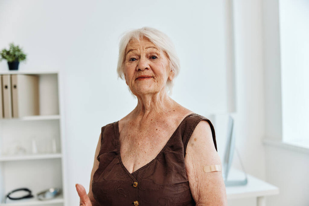 vieille femme avec plâtre sur l'épaule passeport vaccin covid-19 - Photo, image