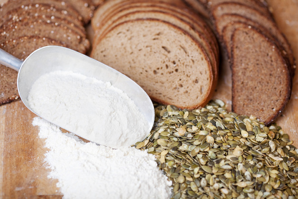 Seeds, flour in scoop and breads - Foto, afbeelding