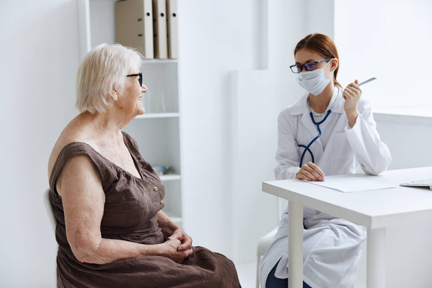 medici dello studio medico che parlano con una donna anziana assistenza sanitaria - Foto, immagini