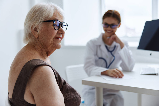 літня жінка консультується з лікарем охорони здоров'я
 - Фото, зображення