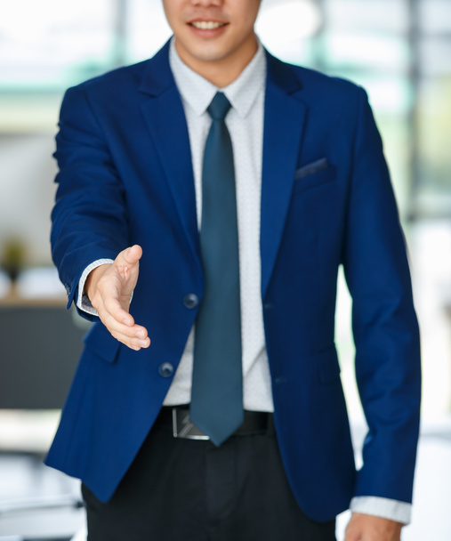 Unerkennbarer männlicher Unternehmer im edlen Anzug steht mit ausgestreckter Hand für Handschlag im Amt. - Foto, Bild