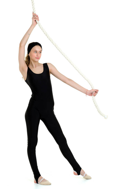 Attractive sports teen girl swinging on rope swing - Фото, зображення