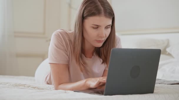 χαρούμενη νεαρή γυναίκα χρήση υπολογιστή στο διαμέρισμα - Πλάνα, βίντεο