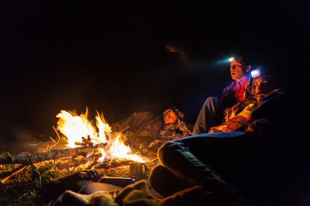 Bonfire in a camp in the mountains and the light of flashlights - Photo, Image