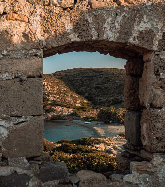 An old stone arch overlooking the azure sea - Фото, зображення