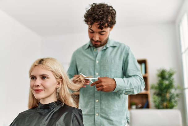 Fiatal férfi hajat vágat a barátnőjének otthon.. - Fotó, kép
