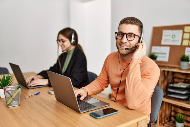 Two caucasian call center agents working at the office. - Photo, Image