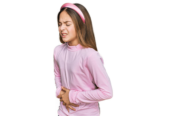Όμορφη μελαχρινή κοριτσάκι φορώντας casual ζιβάγκο πουλόβερ με το χέρι στο στομάχι, επειδή ναυτία, επώδυνη ασθένεια αίσθημα αδιαθεσίας. έννοια του πόνου.  - Φωτογραφία, εικόνα