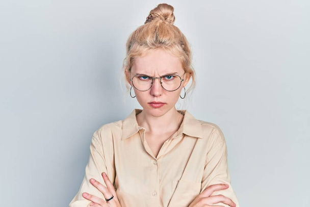 Beautiful caucasian woman with blond hair wearing casual look and glasses skeptic and nervous, disapproving expression on face with crossed arms. negative person.  - Photo, Image