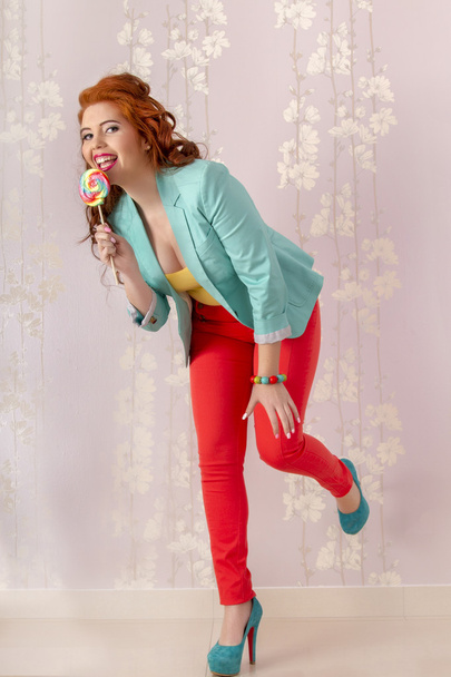 Beautiful redhead girl with a lollipop candy - Фото, зображення