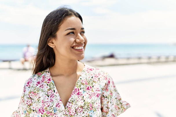 Jeune fille latine souriant heureux debout à la plage. - Photo, image