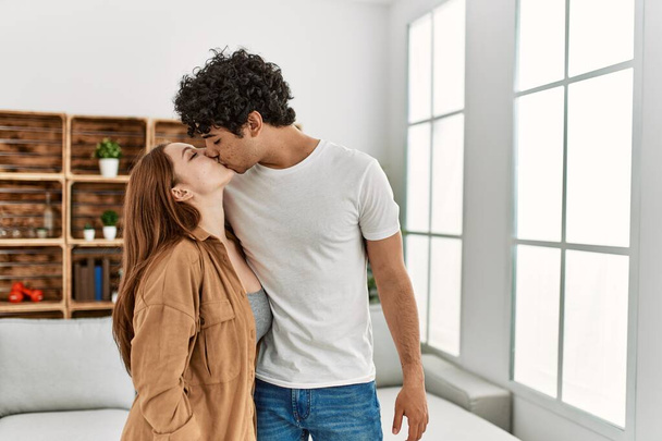 Young couple kissing and hugging standing at home. - Photo, image
