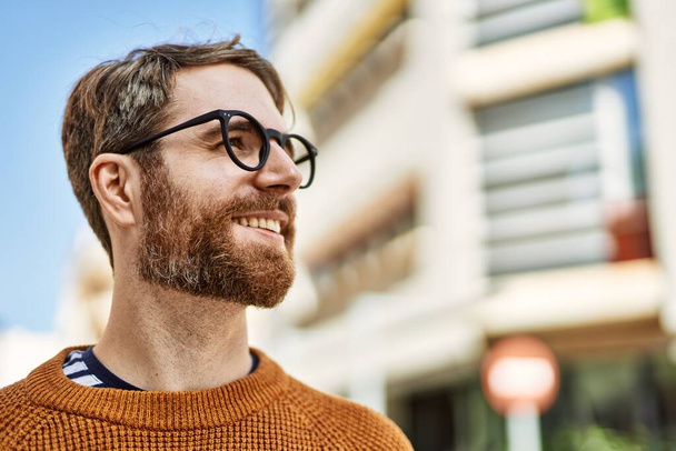 Nuori valkoihoinen mies, jolla on parta silmälasit ulkona aurinkoisena päivänä - Valokuva, kuva