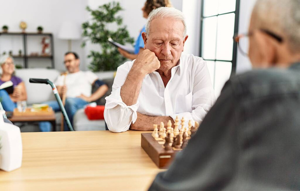 老人はチェスでテーブルに座り - 写真・画像
