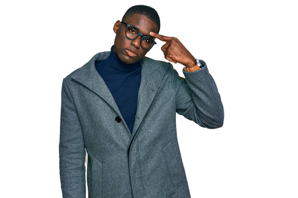 Mladý afroameričan v obchodních šatech a brýlích ukazuje nešťastně na pupínek na čele, ošklivá infekce černých hlav. akné a kožní problémy  - Fotografie, Obrázek