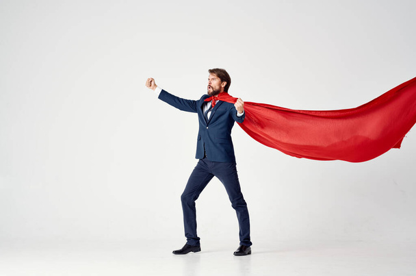 чоловік у костюмі з червоним плащем тримає руку над головою супергеройського світлого фону
 - Фото, зображення