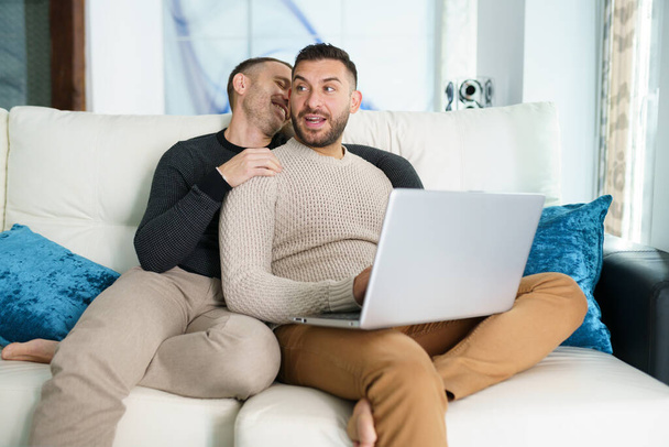 Gay couple consulting their travel plans together with a laptop. - Photo, Image