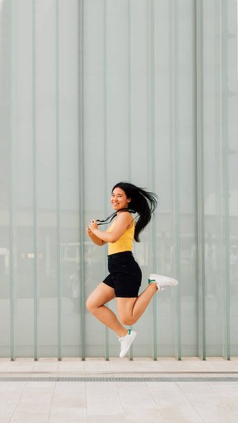 Young asian woman outdoor freelance photographer jumping celebrating success feeling free - advertising copyspace 16:9 banner - Φωτογραφία, εικόνα