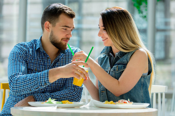 молода пара сидить у кафе і снідає з соком
 - Фото, зображення