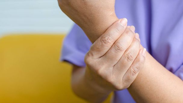 Nő használja a kezét, hogy tartsa a másikat a karon, és fájdalmat érez, szenved, fáj és bizsereg. A Guillain-korlát szindróma és a kézzsibbadás fogalma. - Fotó, kép