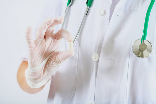 Imagen de cerca de una cápsula transparente sujetada por un médico - Foto, imagen