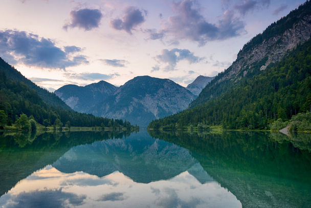 piękne austriackie górskie jezioro plansee z odbiciem gór i chmur w krystalicznie czystej spokojnej wodzie - Zdjęcie, obraz