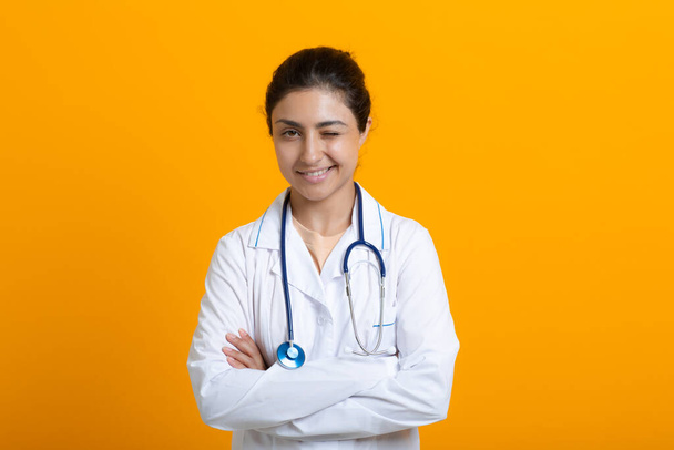 Portrait of indian doctor woman in white medical gown isolated on yellow background - Φωτογραφία, εικόνα