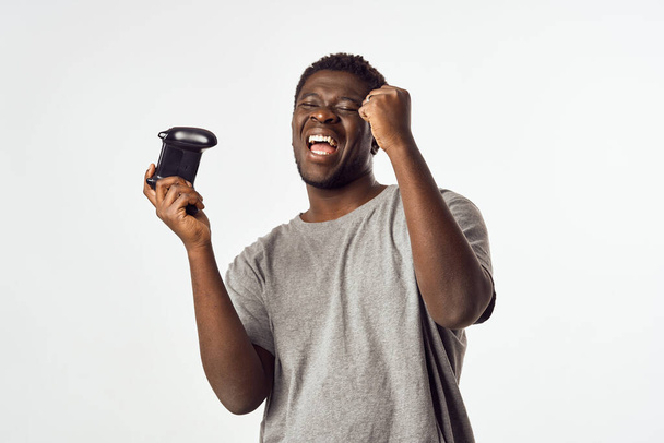 man African εμφάνιση με το gamepad στα χέρια παίζοντας τεχνολογία ψυχαγωγίας - Φωτογραφία, εικόνα