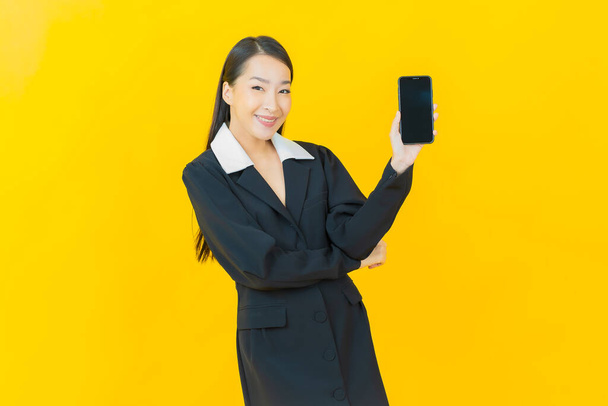 Retrato bonito jovem asiático mulher sorriso com telefone celular inteligente na cor de fundo - Foto, Imagem