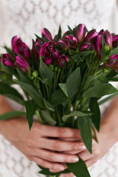 Alstroemeria flowers bouquet. Hands holding fresh flowers - Фото, изображение