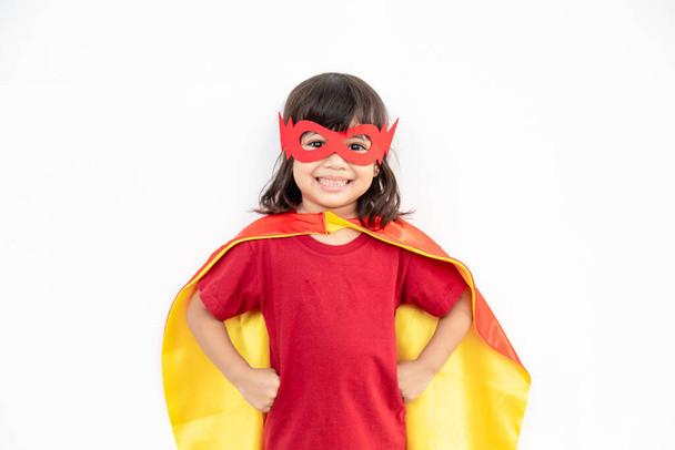 Little child girl plays superhero. Child on the white background. Girl power concept - Zdjęcie, obraz