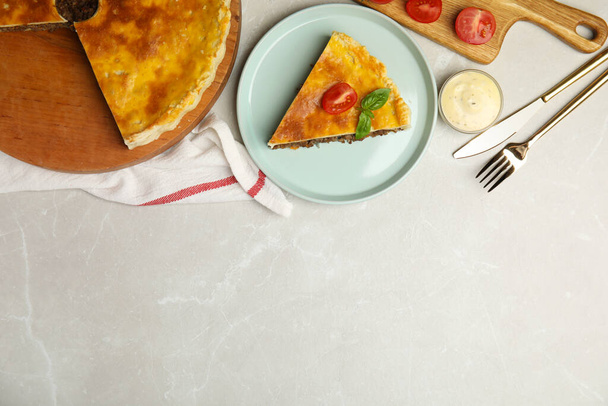 Delicious pie with minced meat, tomato and sauce served on light marble table, flat lay. Space for text - 写真・画像