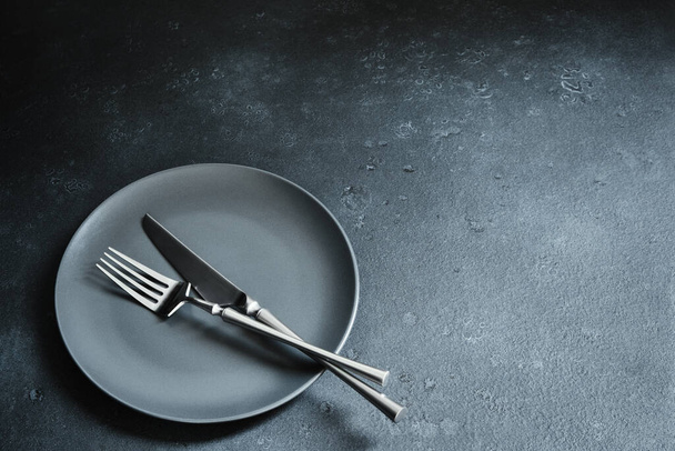 Evőeszközök és étel sötét textúrájú háttérrel. Asztalbeállítás - Fotó, kép