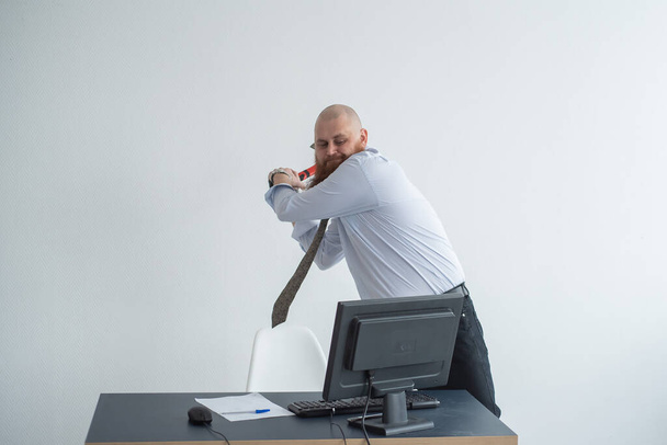 Stressed crazy businessman smashing his computer in office using ax problem concept. The man has problems at work and frustration. - Zdjęcie, obraz