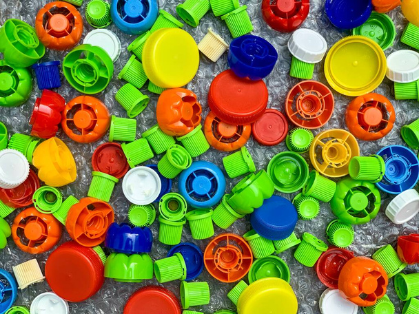 разноцветные пластмассовые колпачки из детского питания, экологическая концепция, переработка, сортировка отходов - Фото, изображение