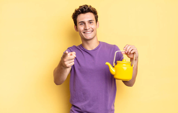 pointing at camera with a satisfied, confident, friendly smile, choosing you. teapot concept - Foto, imagen