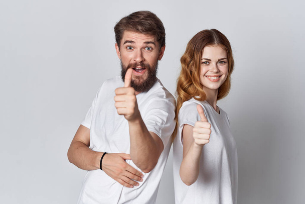 fröhliches junges Paar in weißen T-Shirts Emotionen Studio Werbung Design - Foto, Bild