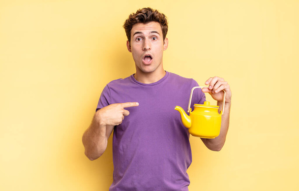 looking shocked and surprised with mouth wide open, pointing to self. teapot concept - Foto, imagen