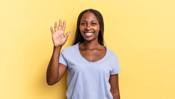 afro μαύρο όμορφη γυναίκα χαμογελά και αναζητούν φιλικό, δείχνει τον αριθμό πέντε ή πέμπτο με το χέρι προς τα εμπρός, μετρώντας προς τα κάτω - Φωτογραφία, εικόνα
